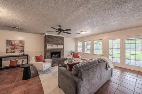a living room with furniture large window and fireplace
