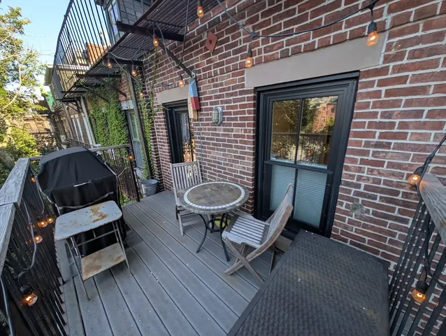 a view of balcony with wooden floor and outdoor seating