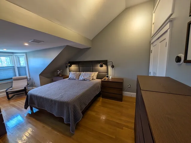 a bedroom with a bed and a flat tv screen on dresser
