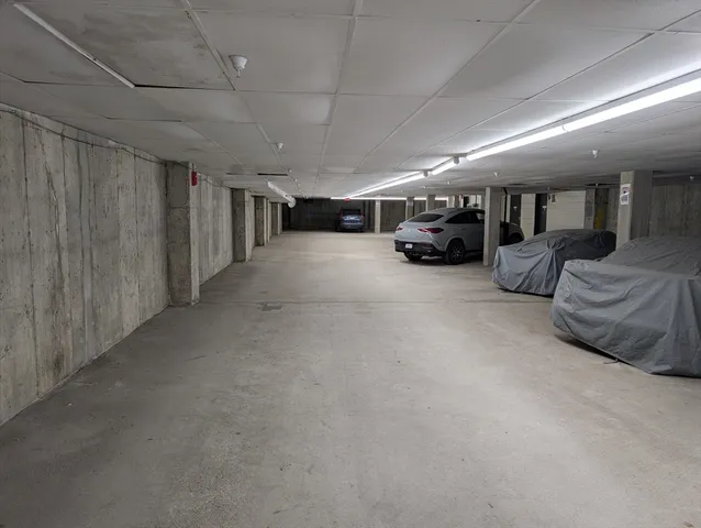 a front view of a multi story residential apartment building with yard and parking space