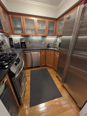 a kitchen with granite countertop a stove top oven cabinetry a sink and a refrigerator