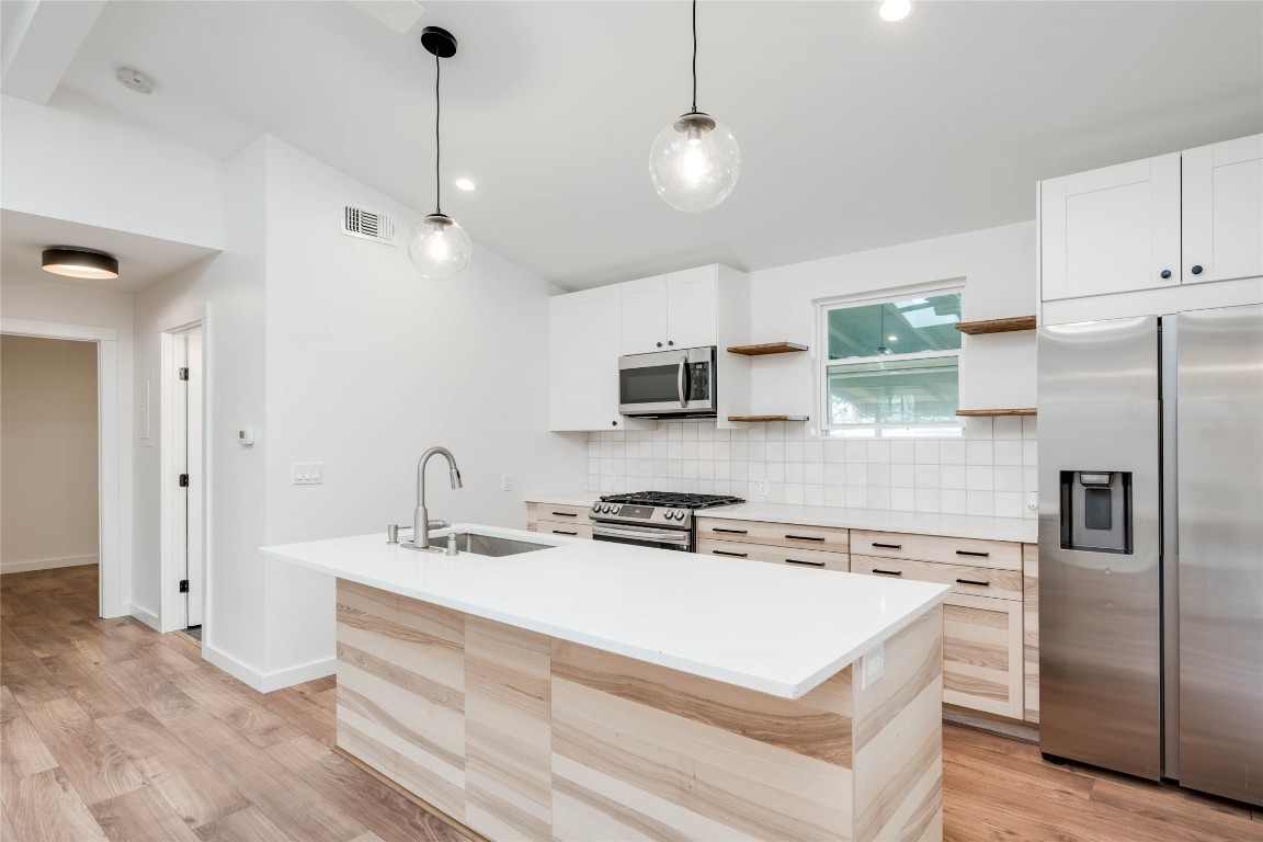 7202 Albert Road Austin, TX 78745 - Photo 1 of 1 a kitchen with stainless steel appliances granite countertop a sink a stove and a refrigerator