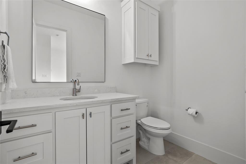 1 Piedra Court Roanoke, TX 76262 - Photo 32 of 40 a bathroom with a toilet a sink and mirror