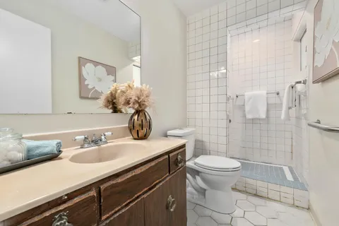 a bathroom with a sink a toilet and shower