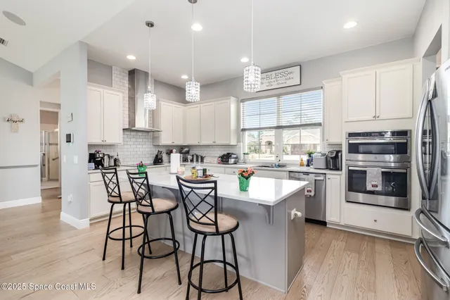 a kitchen with a sink a counter top space stainless steel appliances and cabinets
