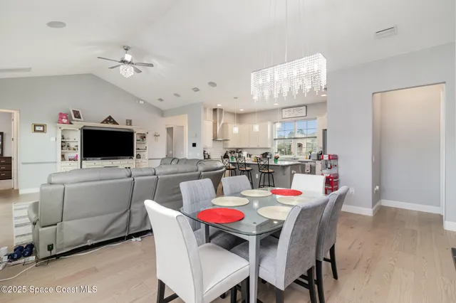 a dining room with kitchen island furniture a flat screen tv and kitchen view