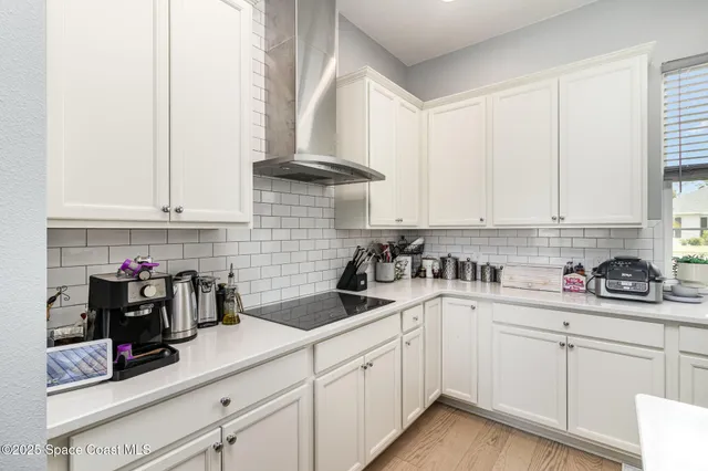 a kitchen with a sink dishwasher and white cabinets
