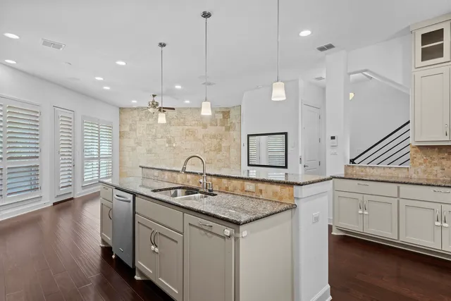 a kitchen with a sink chandelier and wooden floor