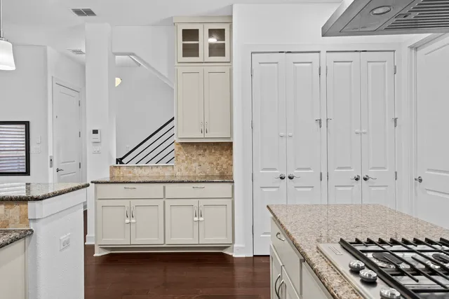 a kitchen with granite countertop a sink and a stove