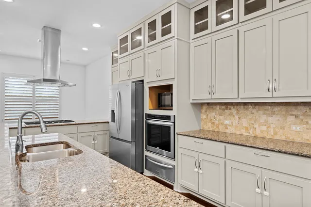 a kitchen with stainless steel appliances granite countertop a refrigerator and cabinets