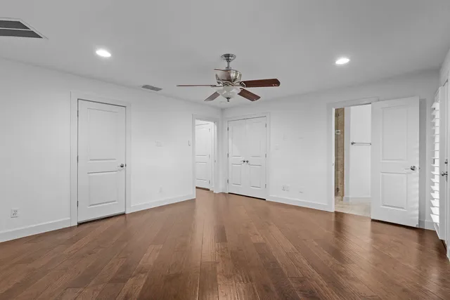 a view of a room with wooden floor and a ceiling fan