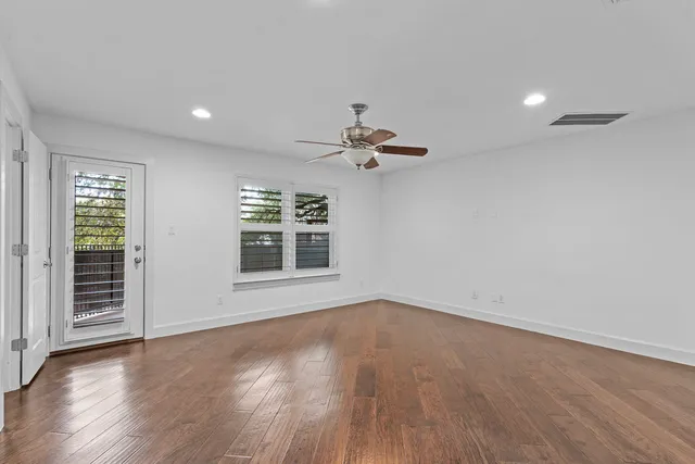 a view of a livingroom with wooden floor and a ceiling fan