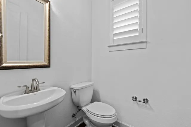 a white toilet sitting next to a bathroom sink