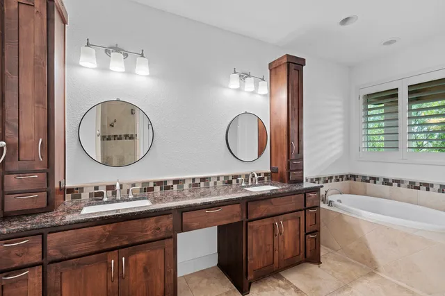 a bathroom with a toilet a double vanity sink and a mirror