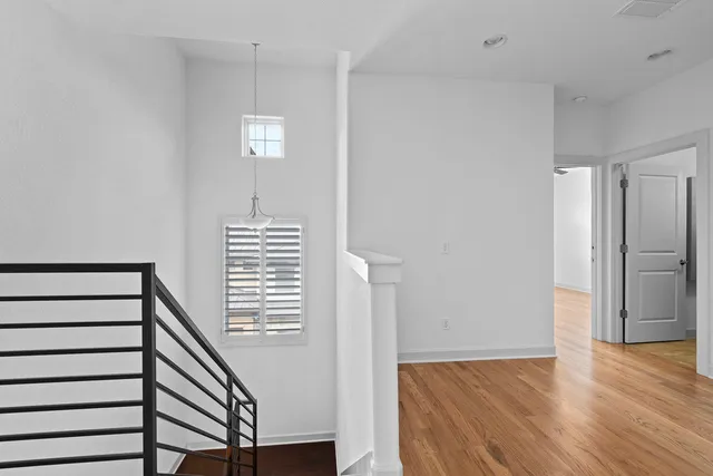 a view of hallway with stairs and wooden floor