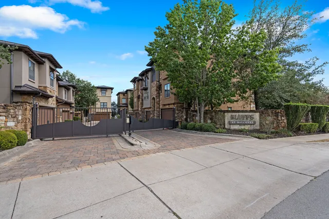 a view of road with house and trees in the background