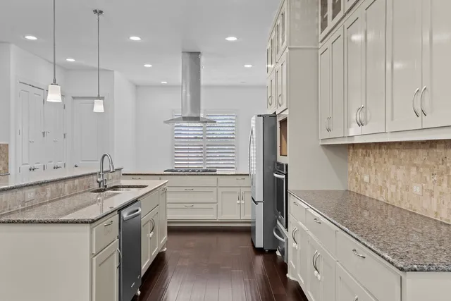 a kitchen with stainless steel appliances granite countertop a sink a stove and a refrigerator