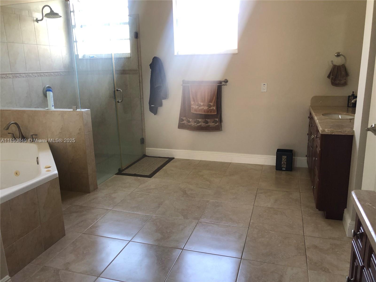 18721 Southwest 291st Terrace Homestead, FL 33030 - Photo 14 of 15 a bathroom with a granite countertop sink a toilet and a shower