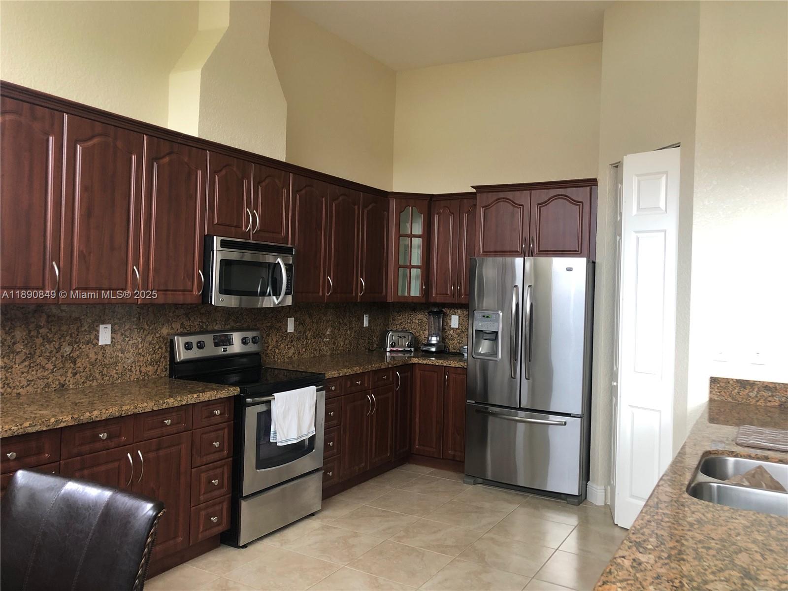 18721 Southwest 291st Terrace Homestead, FL 33030 - Photo 7 of 15 a kitchen with stainless steel appliances granite countertop a refrigerator stove top oven and sink