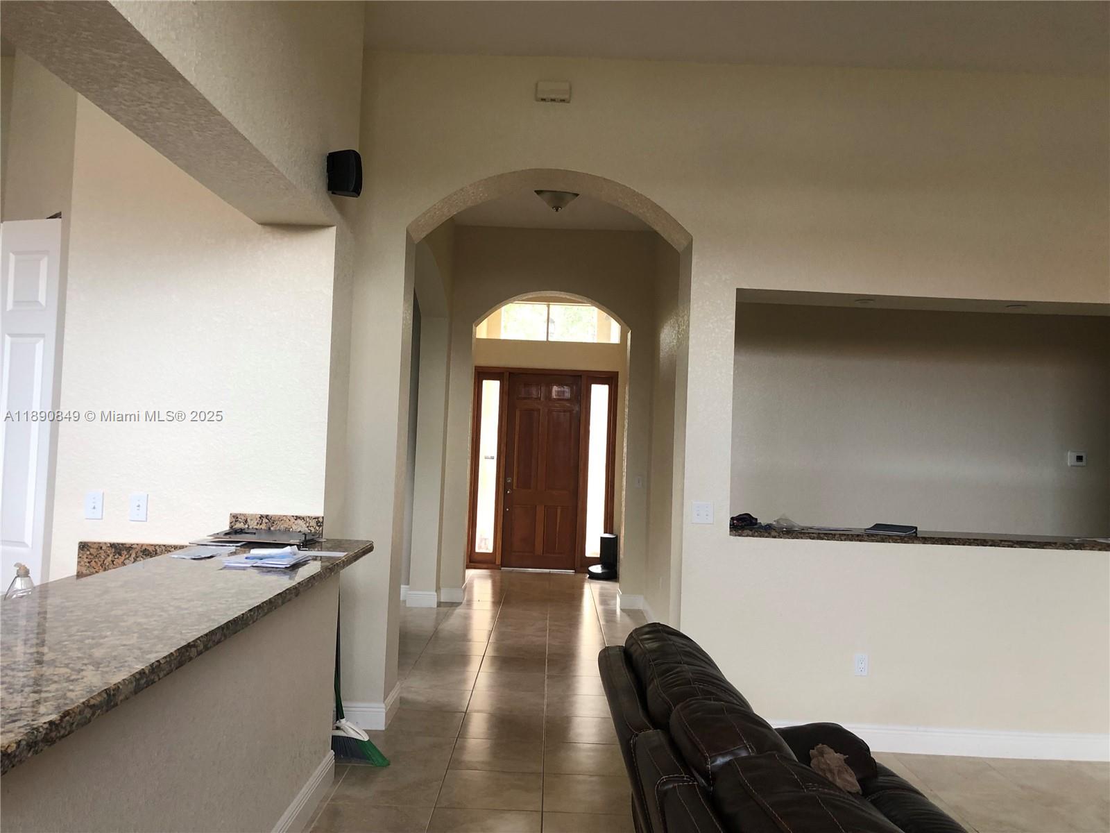18721 Southwest 291st Terrace Homestead, FL 33030 - Photo 9 of 15 a hallway with a large windows and a dishwasher with wooden floor