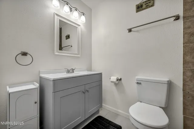 a bathroom with a granite countertop toilet sink and mirror