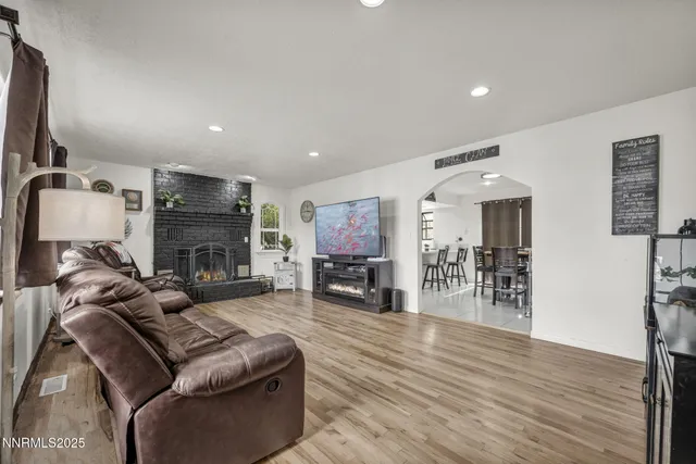 a living room with furniture a fireplace and wooden floor