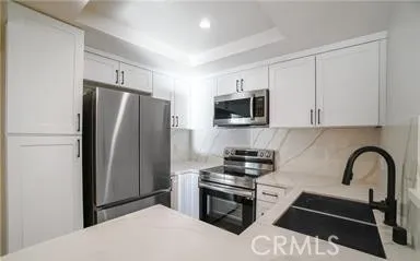 a kitchen with stainless steel appliances a refrigerator stove and microwave