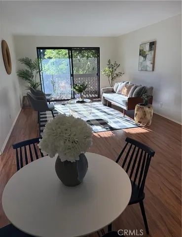 a view of a dining room with furniture a chandelier and wooden floor