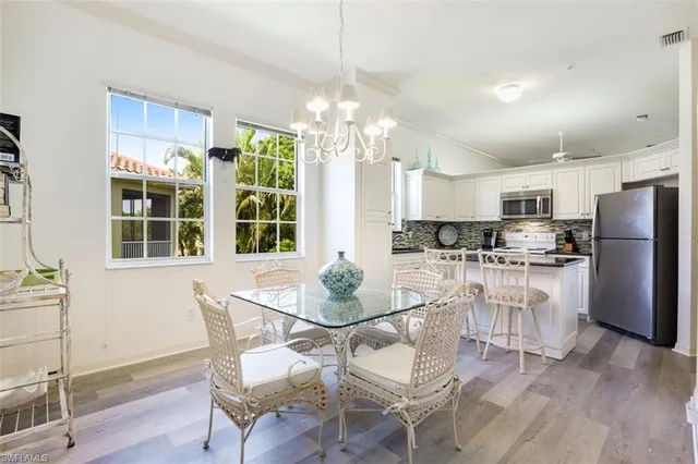 a view of a dining room with furniture a chandelier and wooden floor