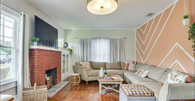 a living room with furniture a fireplace and a large window