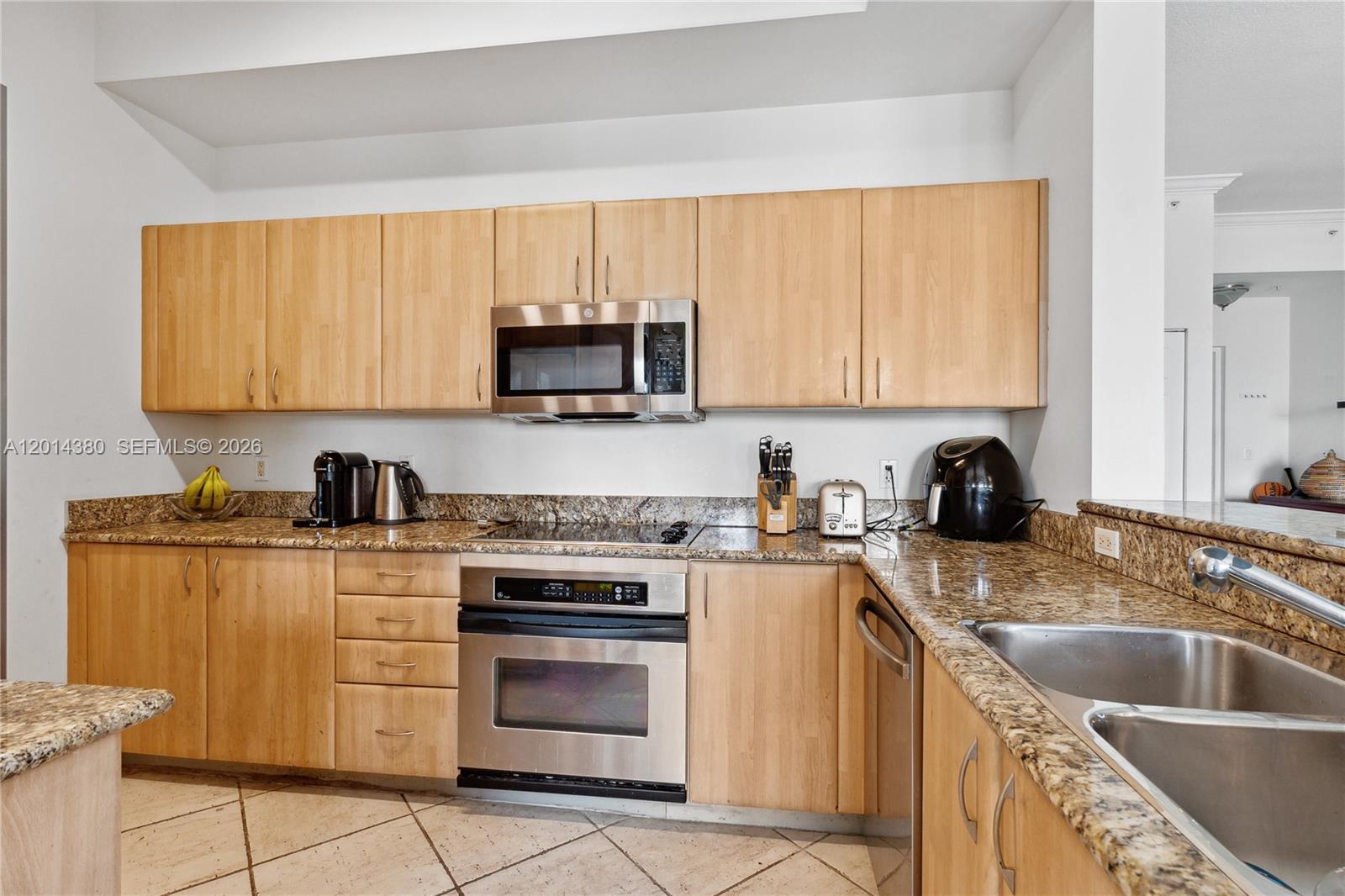 100 Meridian Avenue, Unit 244 Miami Beach, FL 33139 - Photo 15 of 18 a kitchen with stainless steel appliances granite countertop a sink stove and microwave