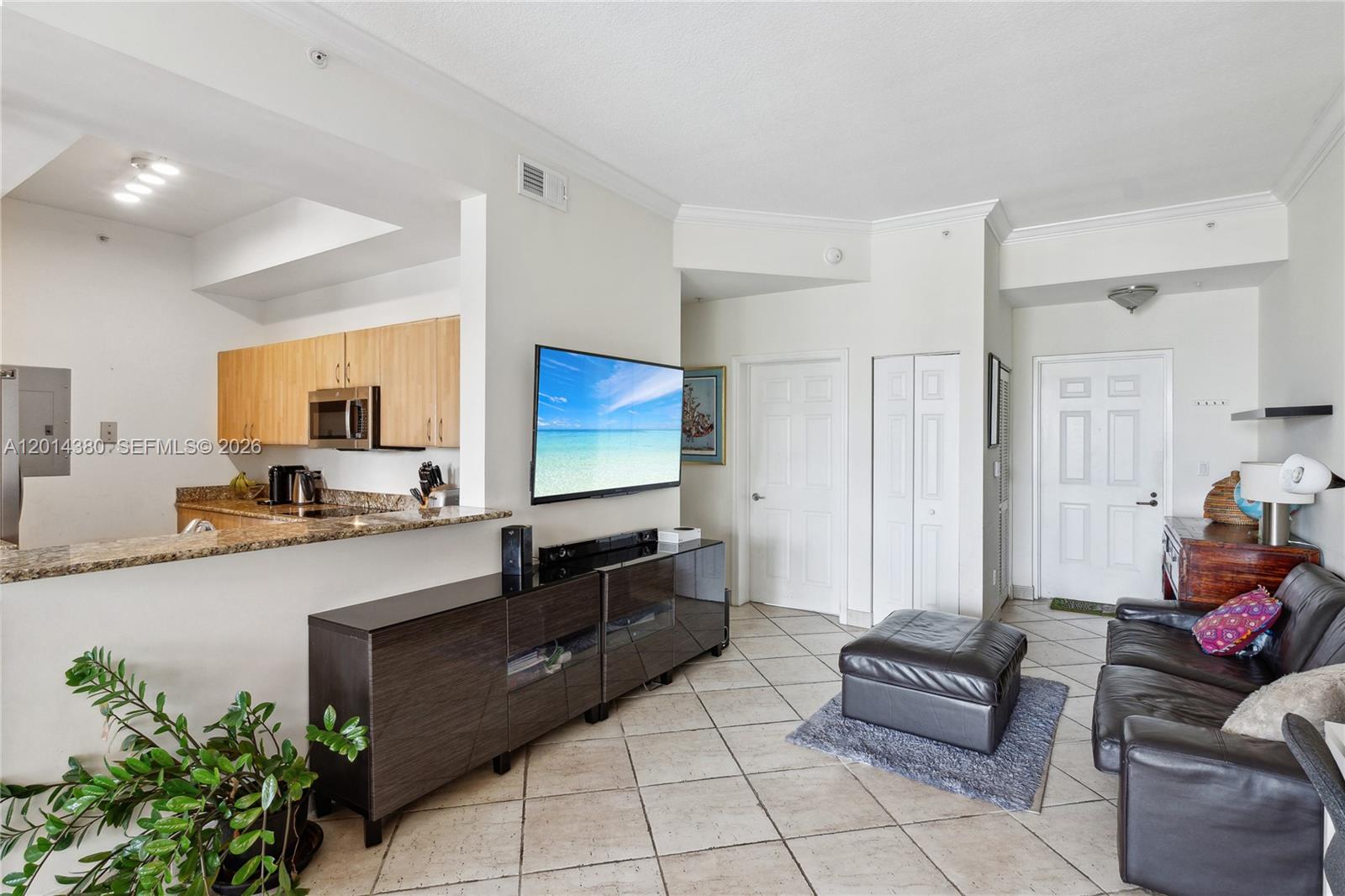 100 Meridian Avenue, Unit 244 Miami Beach, FL 33139 - Photo 2 of 18 a large living room with stainless steel appliances kitchen island granite countertop furniture and a kitchen view