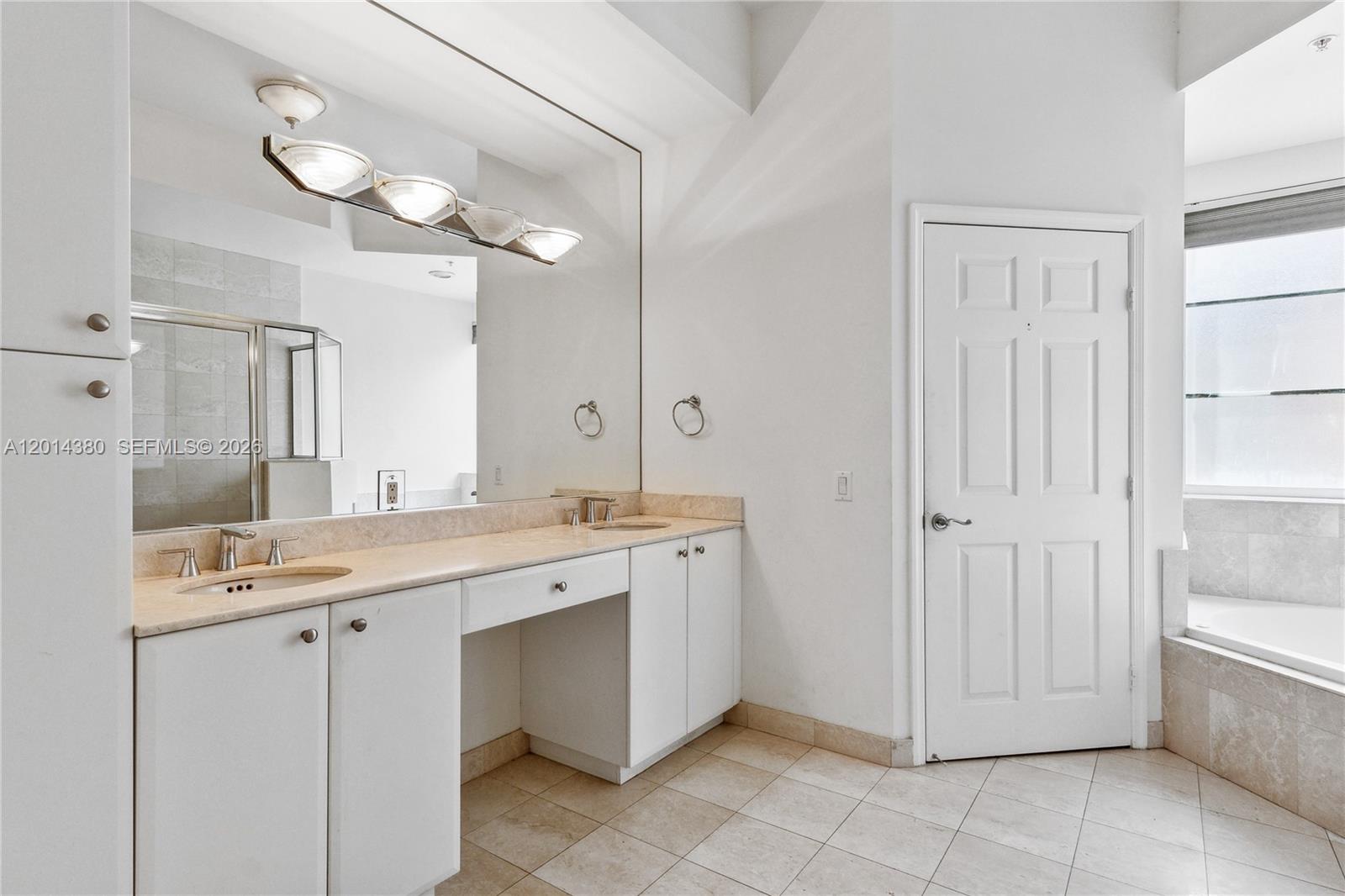 100 Meridian Avenue, Unit 244 Miami Beach, FL 33139 - Photo 10 of 18 a spacious bathroom with a granite countertop sink a mirror and a bathtub