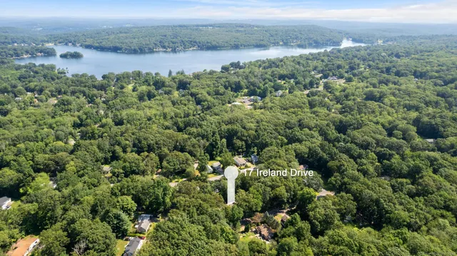 an aerial view of a houses with a yard and lake view