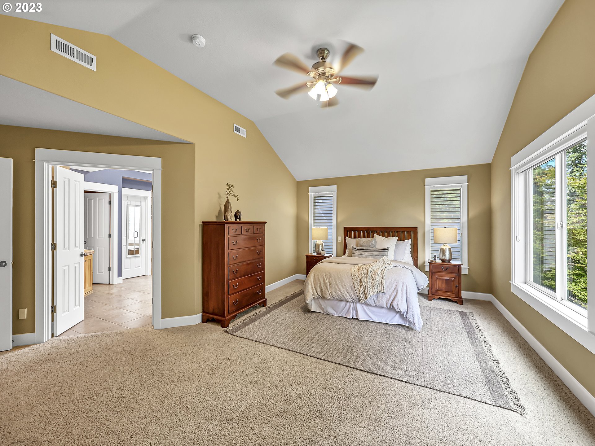 9965 Southwest Choctaw Street Tualatin, OR 97062 - Photo 15 of 25 a spacious bedroom with a large bed and a chandelier