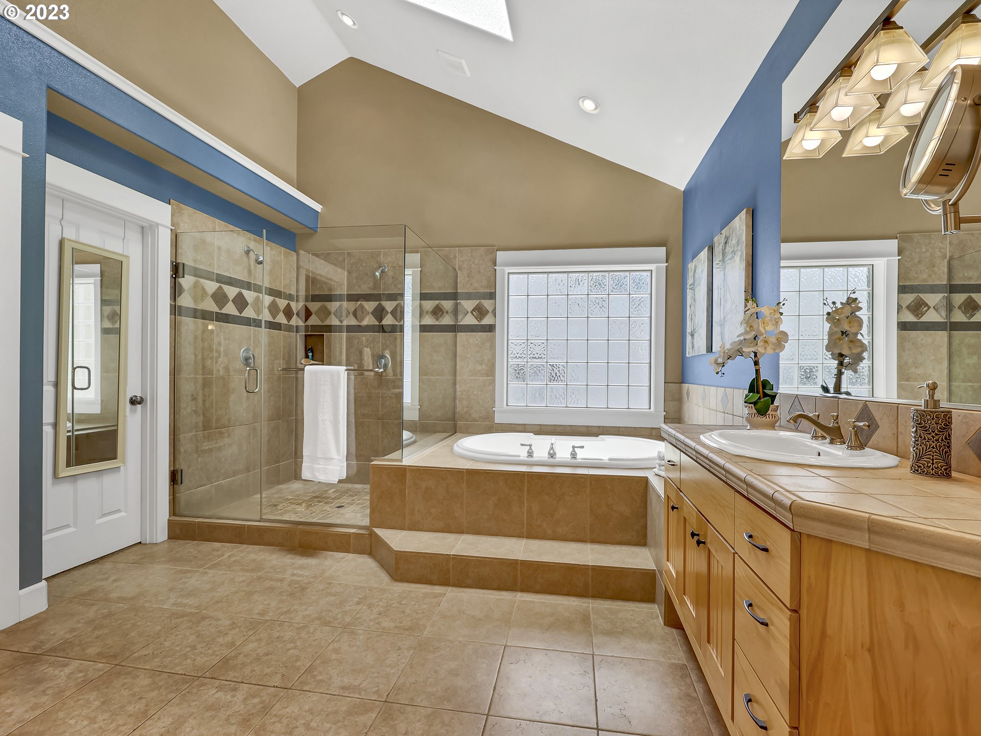 9965 Southwest Choctaw Street Tualatin, OR 97062 - Photo 16 of 25 a spacious bathroom with a tub sink and mirror