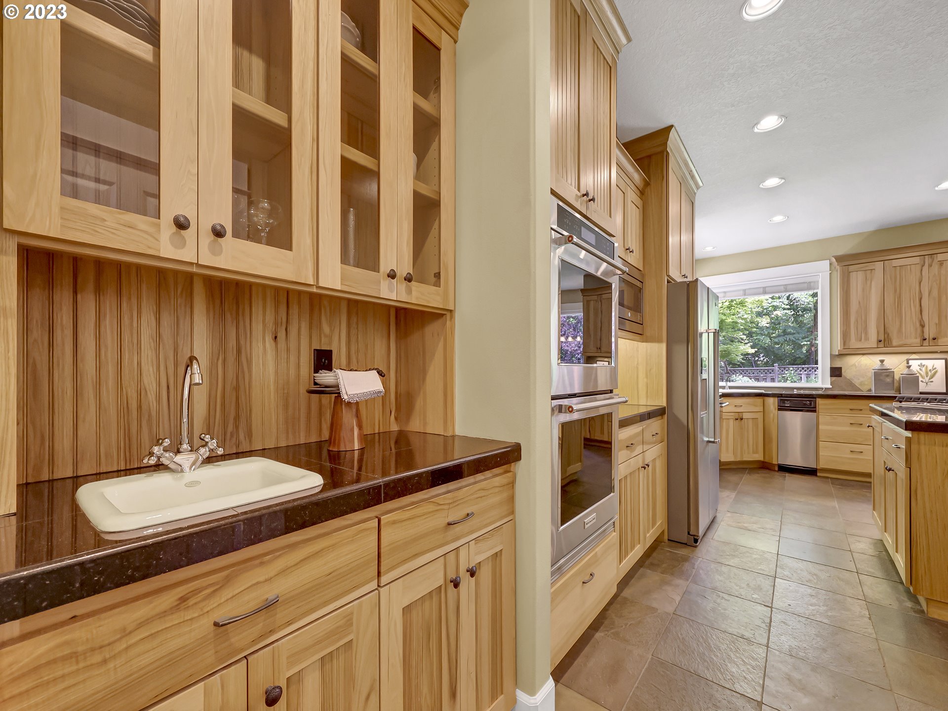 9965 Southwest Choctaw Street Tualatin, OR 97062 - Photo 7 of 25 a kitchen with stainless steel appliances a sink and cabinets