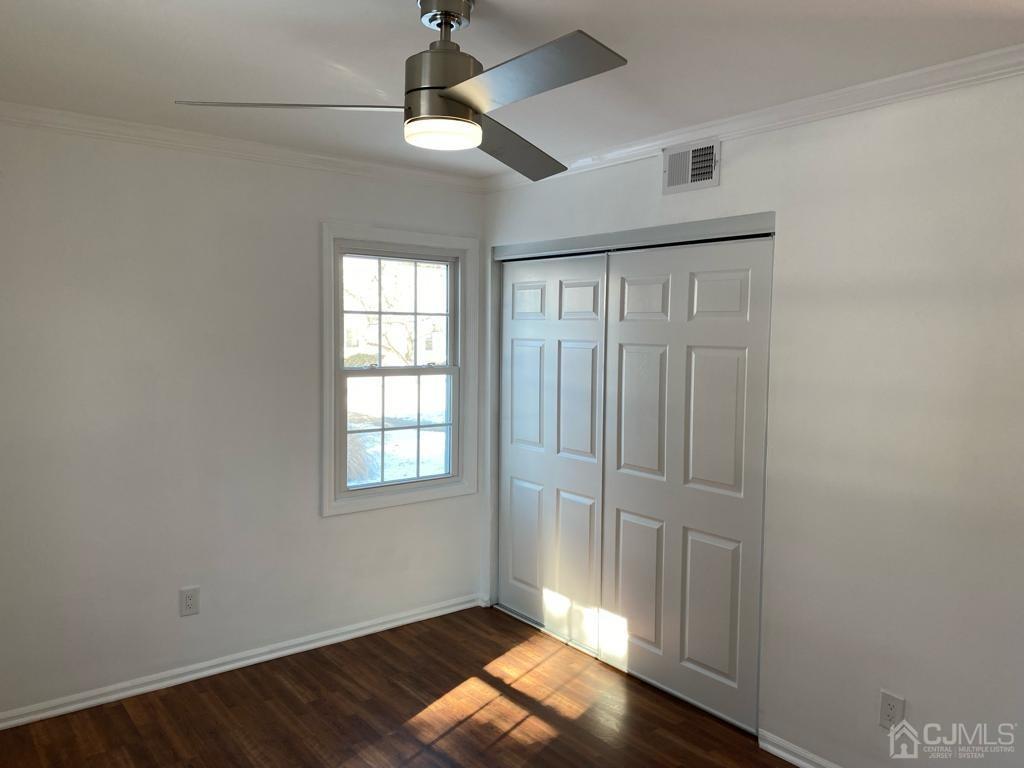 A Zacatin Road Freehold, NJ 07728 - Photo 16 of 25 an empty room with wooden floor chandelier fan and windows