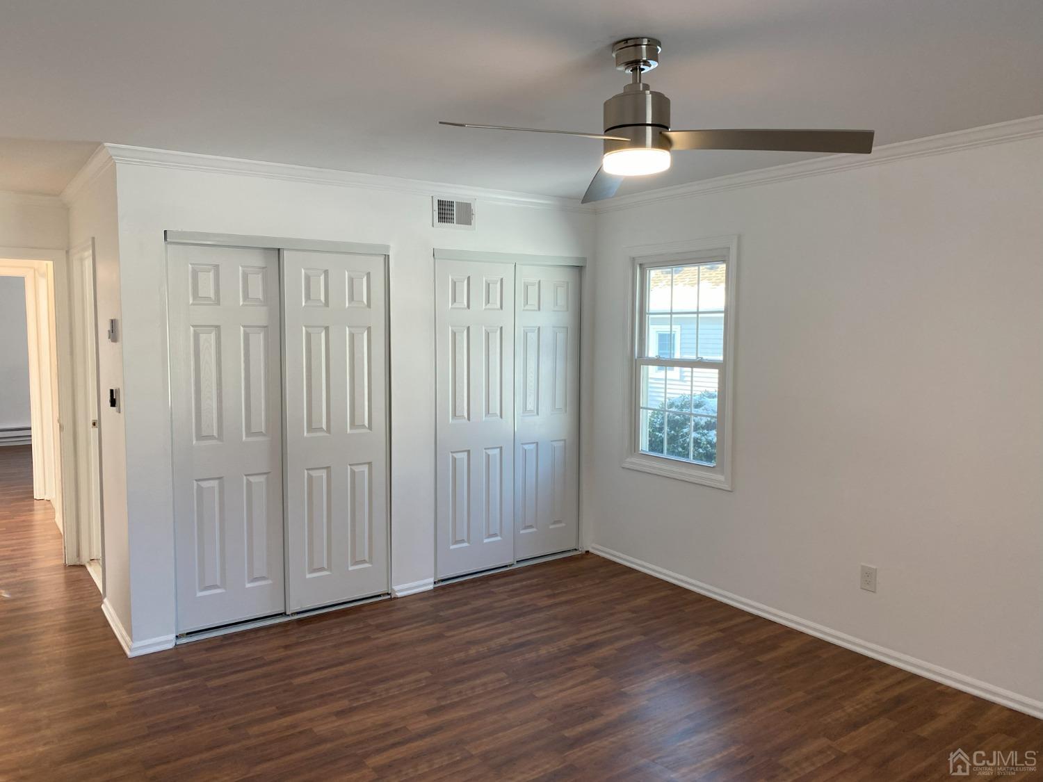 A Zacatin Road Freehold, NJ 07728 - Photo 19 of 25 an empty room with wooden floor chandelier and windows