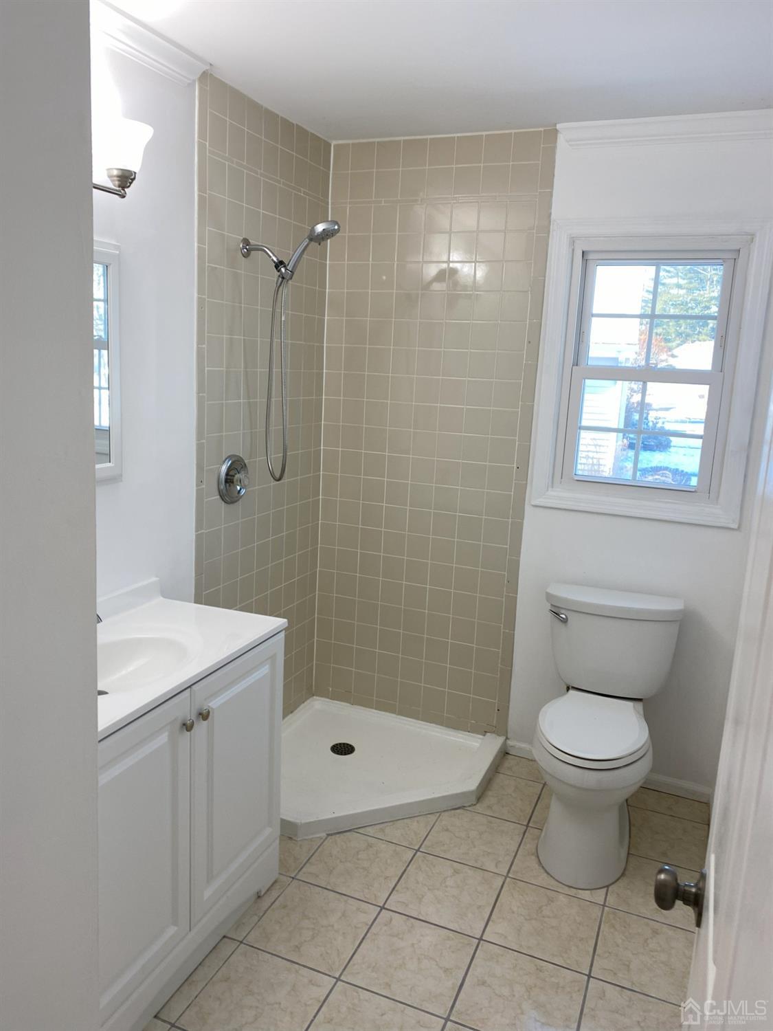 A Zacatin Road Freehold, NJ 07728 - Photo 23 of 25 a bathroom with a granite countertop toilet a sink a mirror and shower