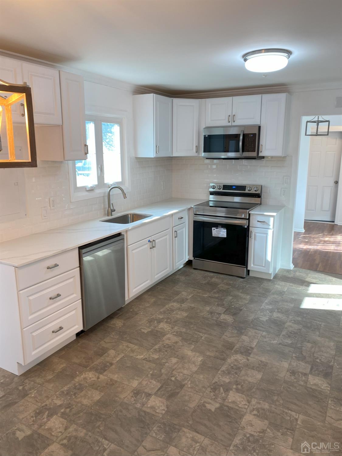 A Zacatin Road Freehold, NJ 07728 - Photo 3 of 25 a kitchen with stainless steel appliances granite countertop a stove a sink and a microwave