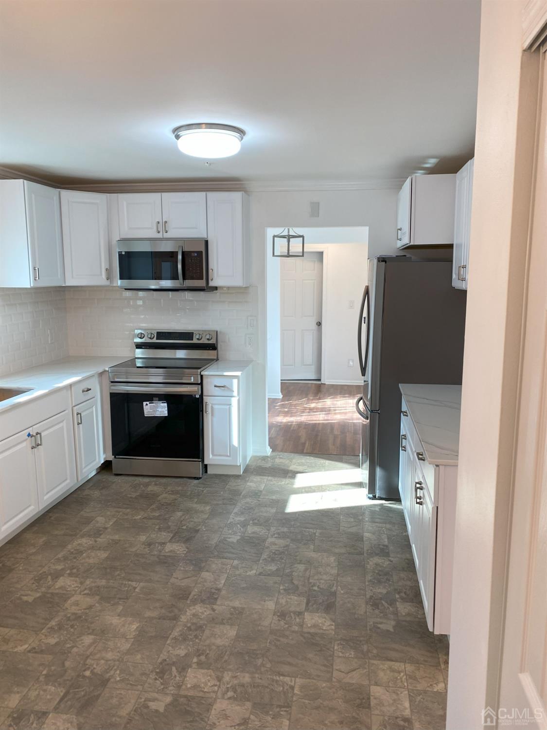 A Zacatin Road Freehold, NJ 07728 - Photo 4 of 25 a kitchen with stainless steel appliances granite countertop a refrigerator and a stove