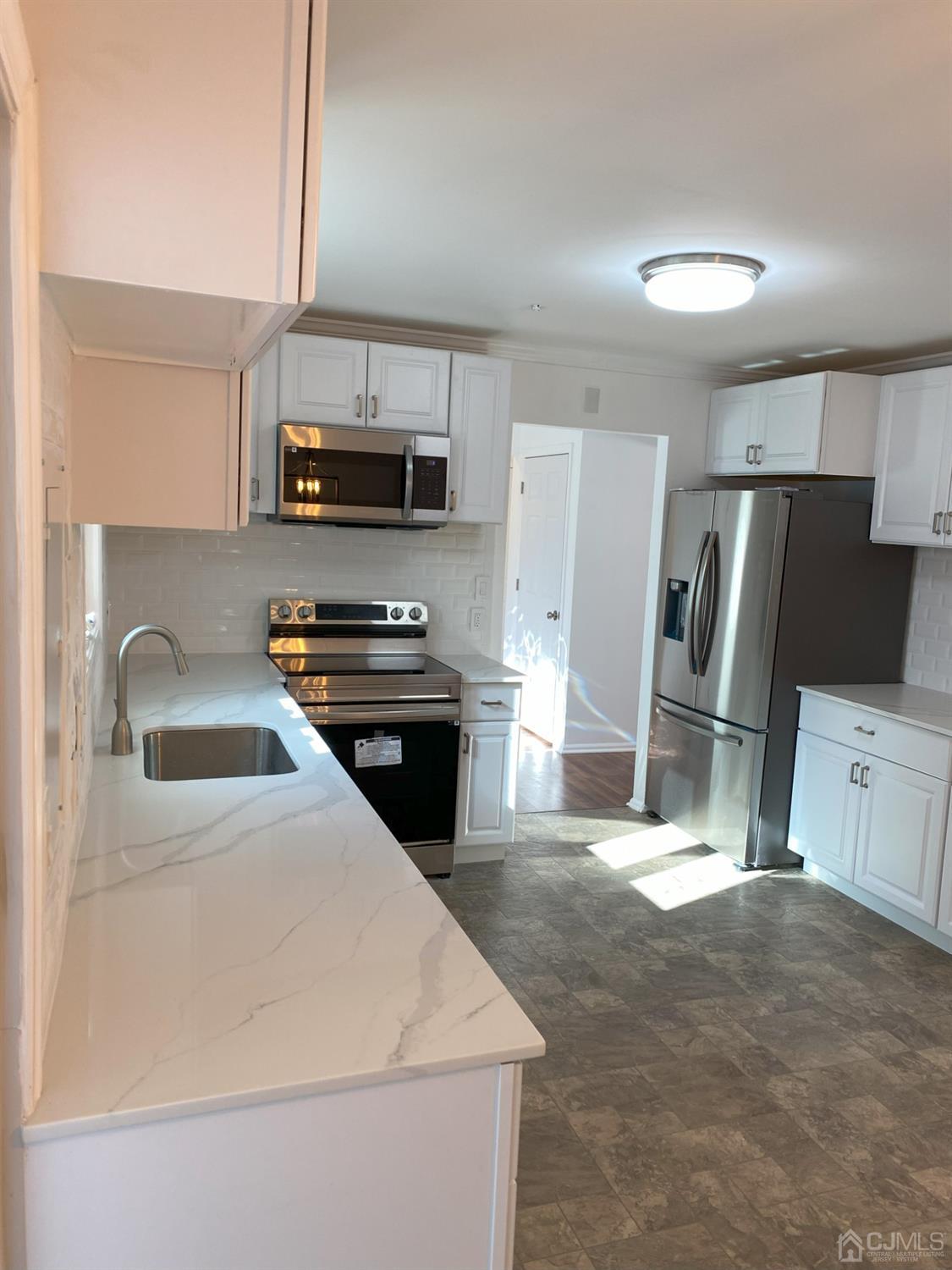 A Zacatin Road Freehold, NJ 07728 - Photo 5 of 25 a kitchen with a refrigerator stove and a sink