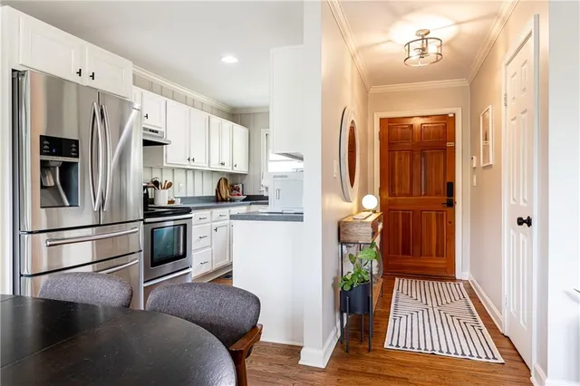 a kitchen with white cabinets and stainless steel appliances