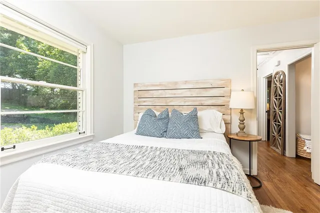 a bedroom with a large bed and a large window with outer view