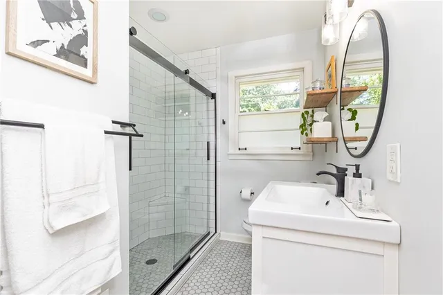 a bathroom with a sink a glass door and a mirror