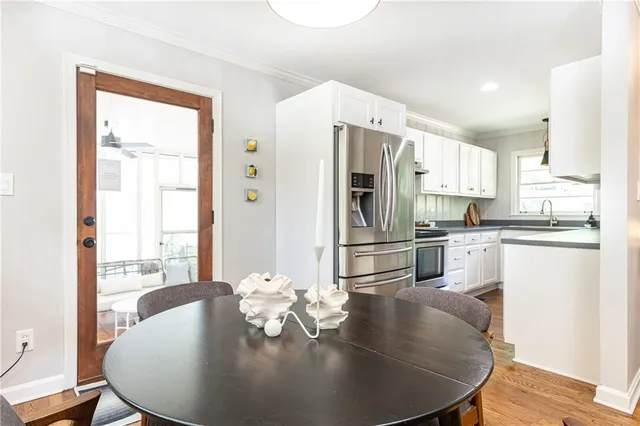 a kitchen with stainless steel appliances wooden floor dining table and chairs