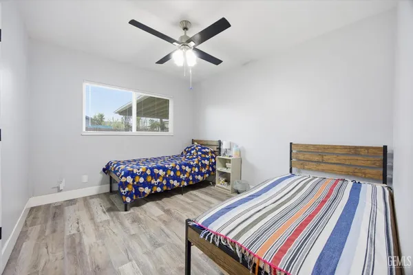 a bedroom with two beds and painting on the wall