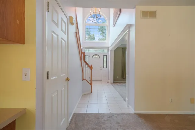 a view of an empty room with window and stairs