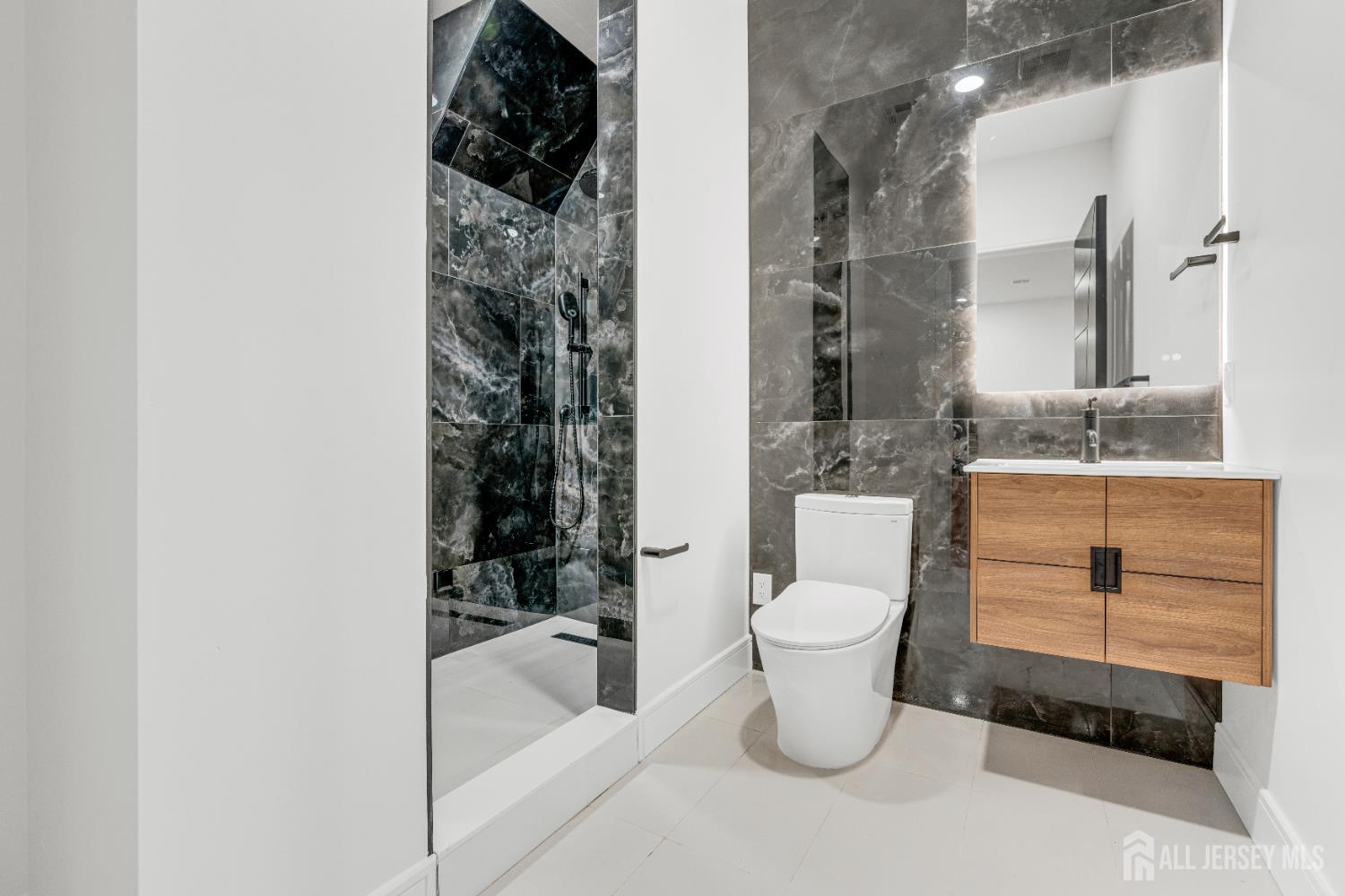 28 Harding Avenue Edison, NJ 08820 - Photo 57 of 62 a bathroom with a toilet sink and mirror
